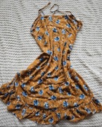 Musztardowa sukienka w kwiaty.