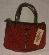 Czerwona torebka damska w czarne cętki.