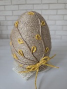 Jajko wielkanocne ręcznie robione z juty na dekoracyjnym stojaku
