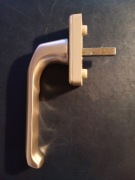 Klamka okienna w kolorze delikatnej miedzi wpadajacej w srebrny