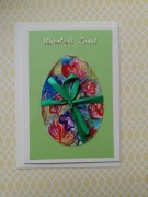 Kartka wielkanocna ręcznie malowana z pisanką z kwiatami i wstążką