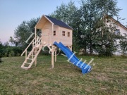 Duży drewniany domek dla dzieci na platformie 