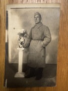 Zdjęcie żołnierza Armii Czerwonej w płaszczu, czapce i kwiatach (1814) 