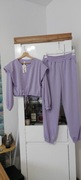 Dres w kolorze lila, bluza krótsza wiązana, spodnie zakończone gumką.