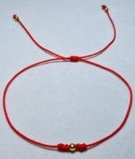 Bransoletka z czerwonego sznurka z koralikiem w kolorze złotym