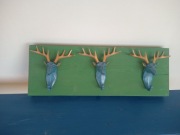 Drewniany wieszak ścienny z 3 haczykami w kształcie głów jeleni. 