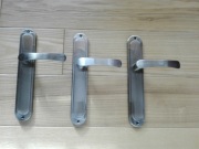 Trzy klamki z szyldami o wysokości 24 cm.