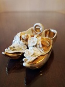 Złote porcelanowe buciki - antyczna pamiątka turystyczna z Clacton-on-Sea