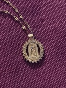 Łańcuszek z medalikiem z Matką Boską z Gwadelupe.