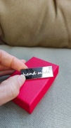 Metalowa metka z napisem „hand made” srebrna