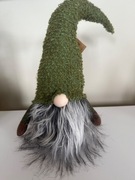 Skrzat świąteczny w zielonym stroju z bujną, siwą brodą. 