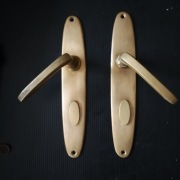 Mosiężne klamki z szyldami.Art deco