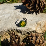 Pierścień z żywicy z zielonym liściem na tle głębokiej zieleni