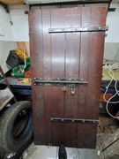 Solidne, drewniane drzwi z okuciami do piwnicy itp