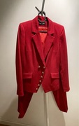 Czerwony garnitur ze złotymi guzikami.