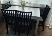 Biały stół z 4 czarnymi krzesłami