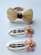 Zestaw do włosów: 1 gumka z kokardą i 2 spinki z kwiatami. Kolor: beżowy