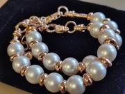 Komplet bransoletek w kolorze różowego złota z perłowymi charmsami.