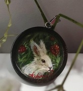 Wisiorek z obrazem białego króliczka i truskawek.