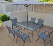 Zestaw stół z parasolem i sześcioma krzesłami.