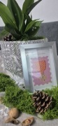 Biała doniczka z konwaliami i srebrną ramką dekoracyjną
