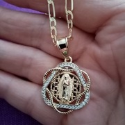 Łańcuszek z medalikiem z wizerunkiem MB z Gwadelupe w kolorze złotym. 