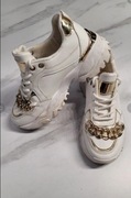 Białe sneakersy ze złotym łańcuchem i wstawkami