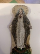 Przedmiotem na zdjęciu jest tekstylna, koralikowa figurka Matki Boskiej