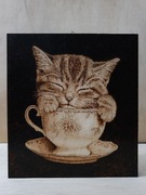 Ręcznie wypalany obrazek kota w filiżance. 