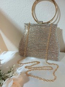 Piękna złota torebka wizytow na okrągłych kołach.