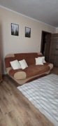 Rozkładana sofa z brązowo-beżową tapicerki, funkcja spania / wersalki