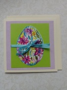 Kartka wielkanocna ręcznie malowana z pisanką z kwiatami i wstążką