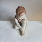 Chłopczyk wiążący but porcelana Aquincum 