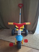 Rowerek trojkołowy z kijem FEBER niebieski czerwony żółty 