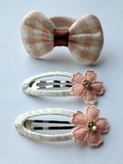 Zestaw do włosów: 1 gumka z kokardą i 2 spinki z kwiatami. Kolor: beżowy