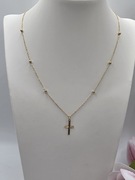 Krzyżyk na łańcuszku z kuleczkami.