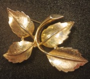 Zabytkowa amerykańska broszka, w kształcie gałązki z liśćmi 