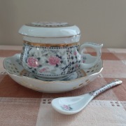 Filiżanka ceramiczna do zaparzania ze spodkiem i łyżeczką.
