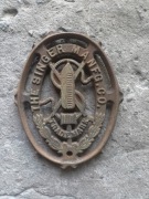 Stary żeliwny emblemat firmy Singer maszyna do szycia dekoracja oryginał 