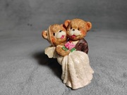 Figurka para niedźwiadków w strojach ślubnych.