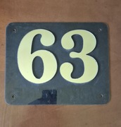 Tabliczka adresowa na posesję z numerem 63