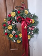 Wianek świąteczny z pomarańczami, czerwoną kokardą, światełkami