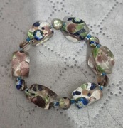 Bransoletka z białymi wzorzastymi szklanymi koralikami. 