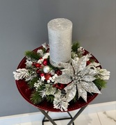 Elegancki świąteczny stroik na czerwonym talerzu.