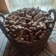 Piękny wielki kosz z trawy morskiej wypełniony korkami do wina korki