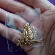 Łańcuszek z medalikiem z wizerunkiem MB z Gwadelupe w kolorze złotym. 