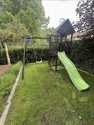 Drewniany domek ze zjeżdżalnią i huśtawką