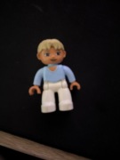 Kobieta z jasnoniebieską bluzką i białymi spodniami unikat Lego duplo