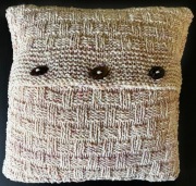 Dekoracyjna poduszka robiona na drutach z owczej wełny.