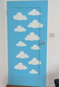 Ręcznie malowane drzwi dziecięce – niebieski baby blue z chmurkami 